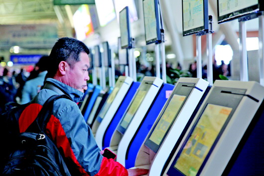 春運首日,乘坐航班出行的旅客正在自助值機機器前辦理手續.